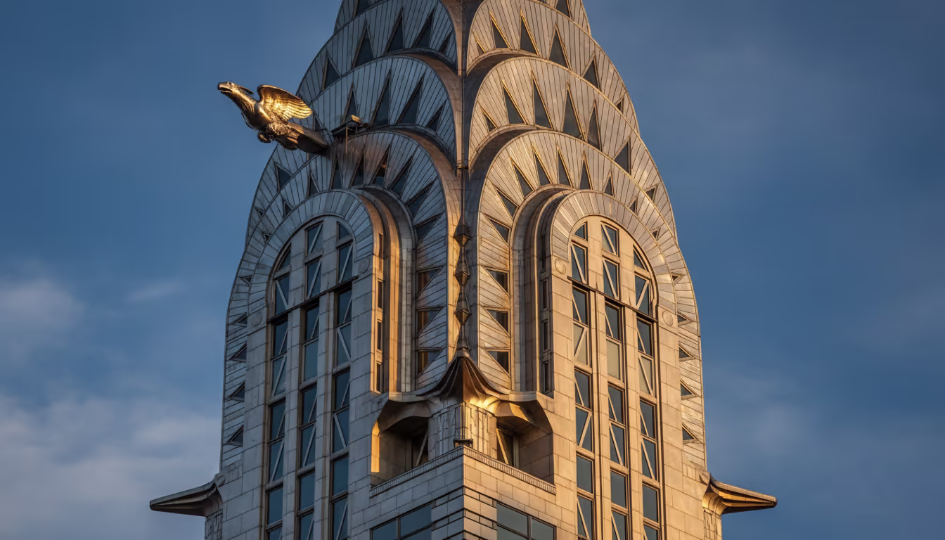 Chrysler Building crown detail — stainless steel sunburst arches, geometric triangular windows, dramatic low angle
